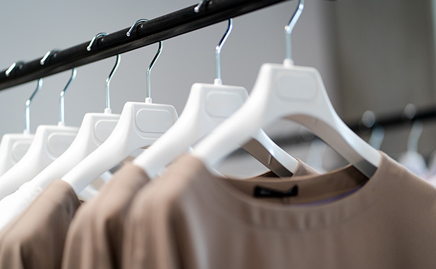 Mehrere Shirts an Kleiderbügeln hängend